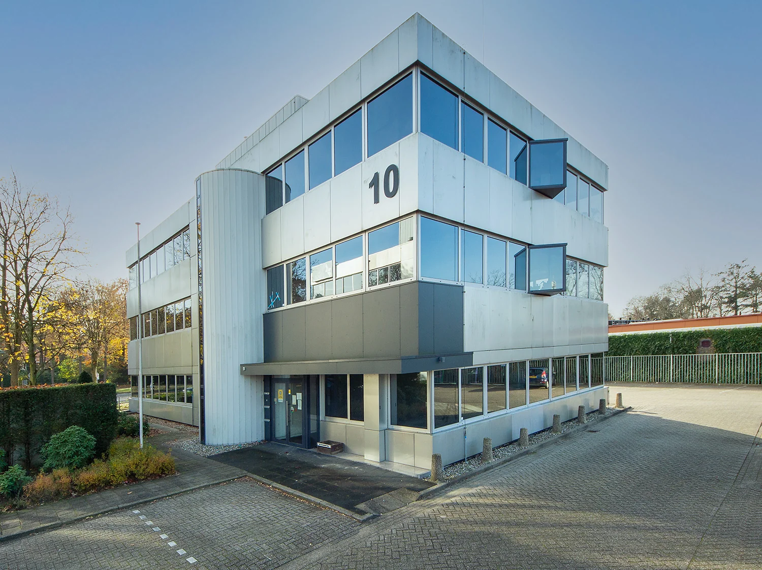 Modern kantoorgebouw aan de Huis ter Heideweg 10 met grote ramen en een zilvergrijze gevel.
